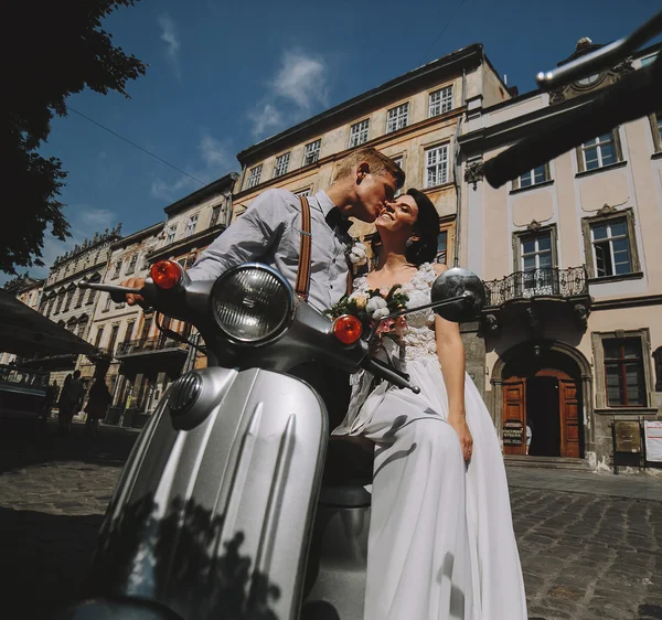Bride and groom on vintage motor scooter — Stock Photo, Image
