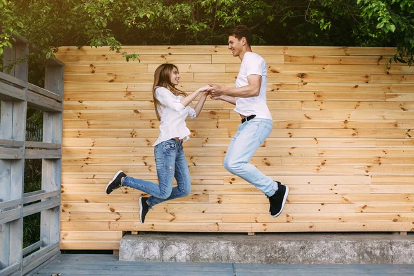 Paar poseren op een achtergrond van de houten muur — Stockfoto