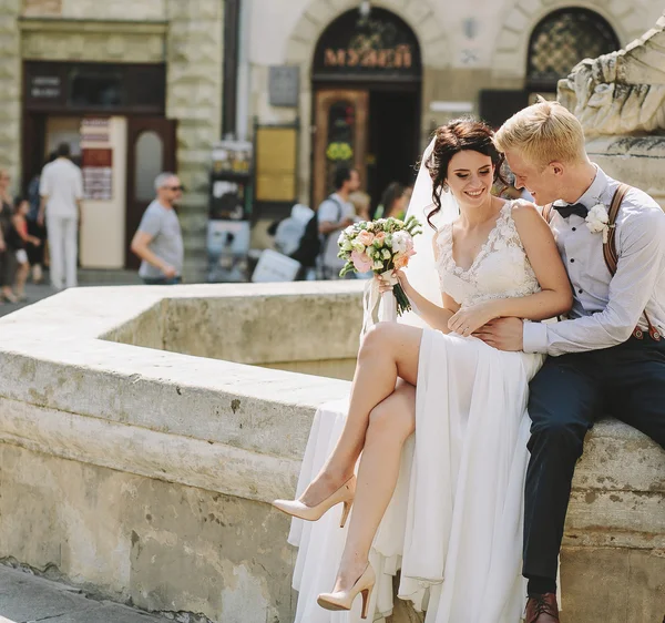 Mariée et marié posant à la fontaine — Photo