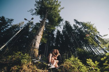 güzel çift bir orman ağacı yanında oturan