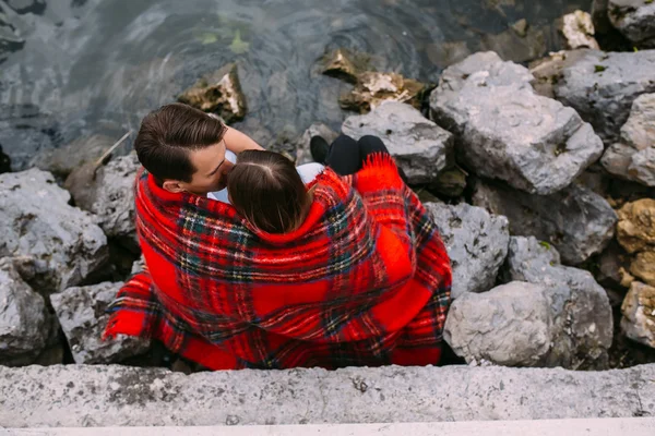 Pareja sentada en un terraplén de piedra — Foto de Stock