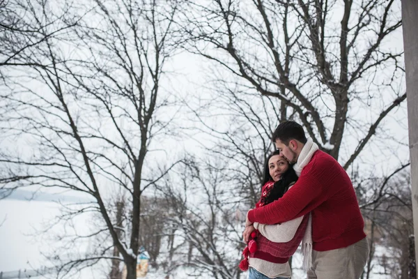 Man and woman hugging in snow-covered park — Stock Photo, Image