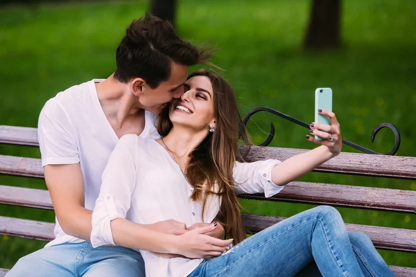 Muž a žena v parku, aby selfie — Stock fotografie