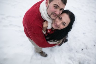 erkek ve kadın karla kaplı parkta sarılma