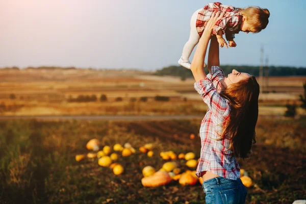 Madre e figlia su un campo con zucche — Foto Stock