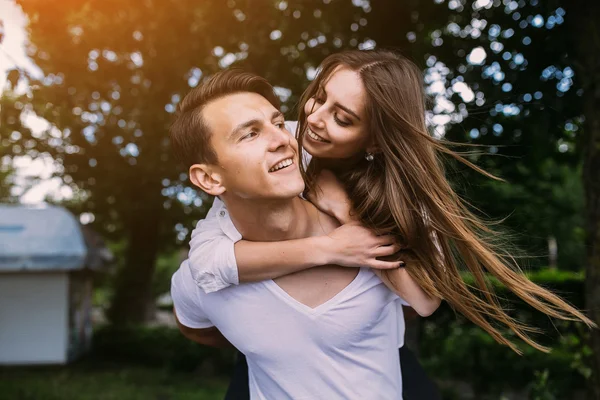 Young adult brunette man and woman in the park — Stock Photo, Image