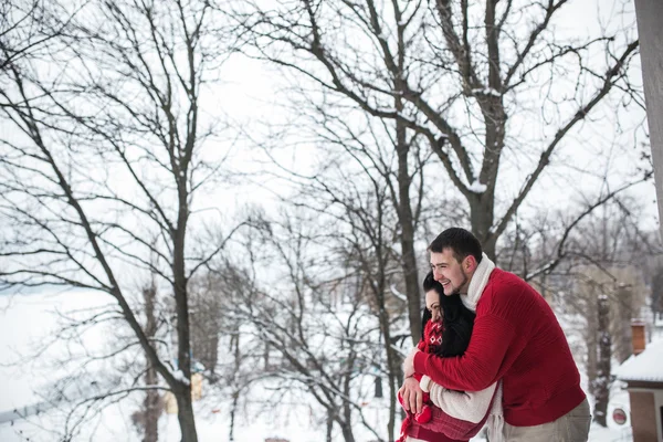 Man and woman hugging in snow-covered park — Stock Photo, Image