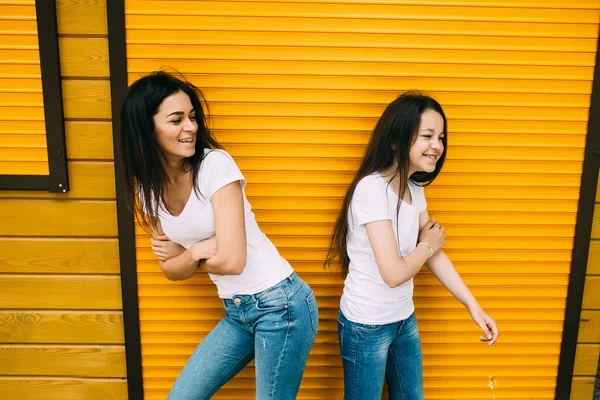 Mãe e sua filha bonito, contra a parede — Fotografia de Stock