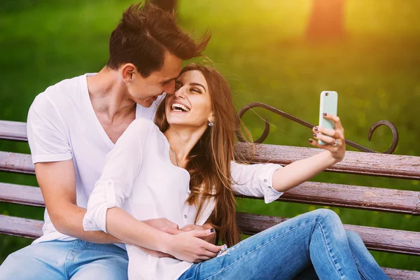Man och kvinna i en park gör selfie — Stockfoto