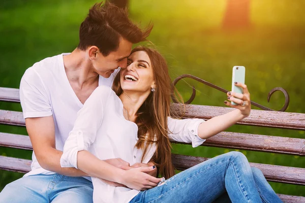 Homem e mulher em um parque fazer selfie — Fotografia de Stock