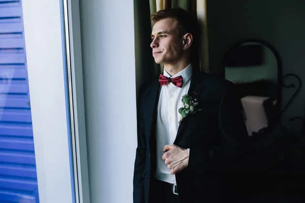 Groom standing at the window — Stock Photo, Image