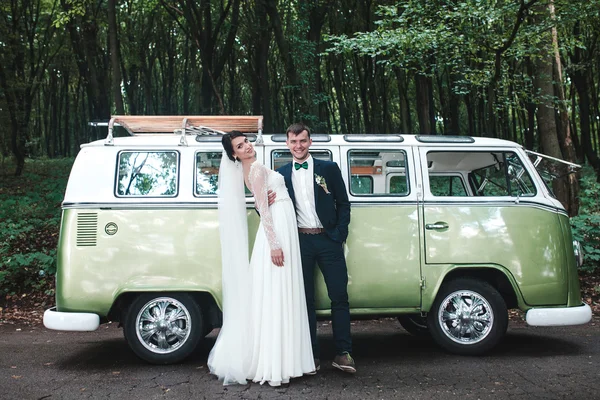 Braut und Bräutigam posieren vor Auto — Stockfoto
