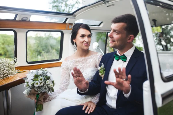 Невеста и жених сидят в машине — стоковое фото