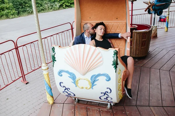 Volwassen man en vrouw op een carrousel — Stockfoto
