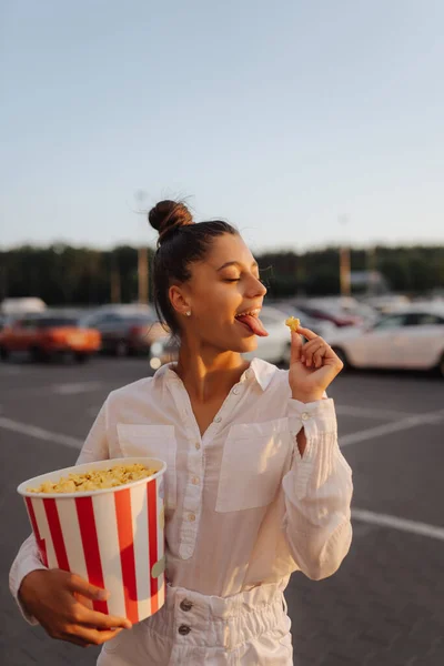 Jonge leuke vrouw met popcorn in een winkelcentrum parkeerplaats — Stockfoto