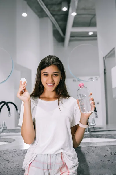 Painting of a beautiful young woman with a cotton pad in the bathroom — Stock Photo, Image