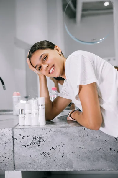 Pintura de uma mulher com garrafas de cosméticos no banheiro — Fotografia de Stock