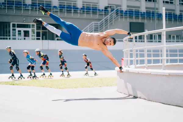 Jeune homme athlétique effectue des éléments de gymnastique - drapeau humain. — Photo