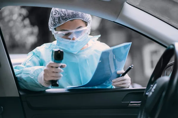 Läkare kvinna använder infraröd termometer pistol för att kontrollera kroppstemperaturen — Stockfoto