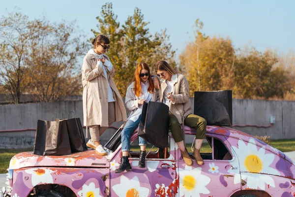 Jovens mulheres posando no velho carro decorado — Fotografia de Stock