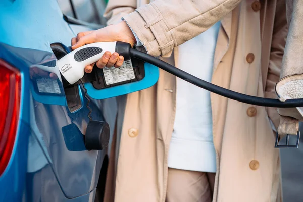 Friends refuel car in gas station. Close up view