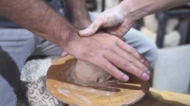 Öğrenci iş için kil hazırlar. Ustayla çömlek dersi.