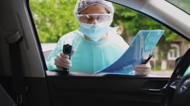 Doctor mujer utilizar pistola de termómetro infrarrojo para comprobar la temperatura corporal — Vídeo de stock