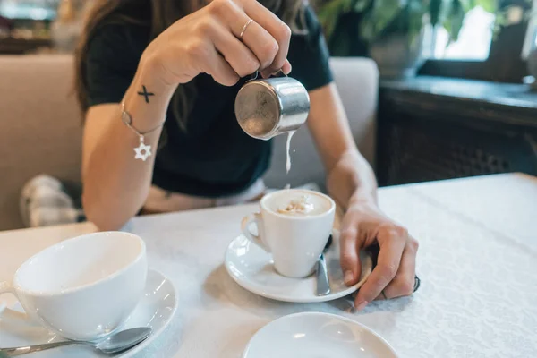 ใกล้ชิด, มือของเด็กสาว, เทครีมหรือนมลงในกาแฟ — ภาพถ่ายสต็อก