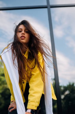 Güzel bir genç kadının dışarıda eğlenip poz verirken portresi..