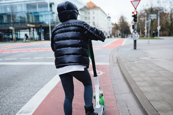 Mooie jonge vrouw paardrijden een elektrische scooter, straat-stijl — Stockfoto