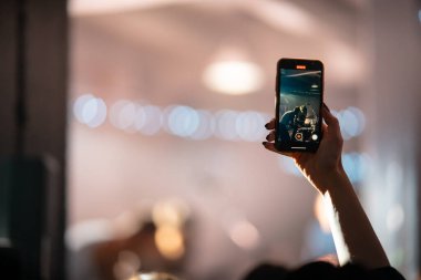 Konser sırasında akıllı telefonla video kaydını kapatan kişi.