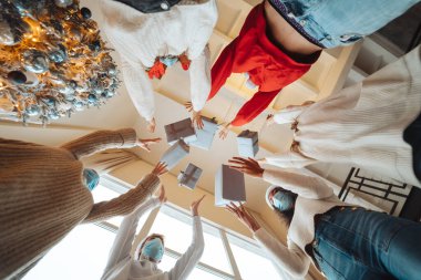 Çok ırklı arkadaşlar Noel hediyelerini havaya fırlatıyorlar..