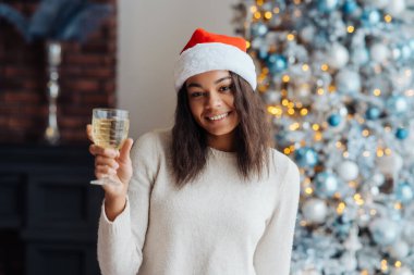 Evde bir bardak şampanyası olan Afrikalı Amerikalı kadın..