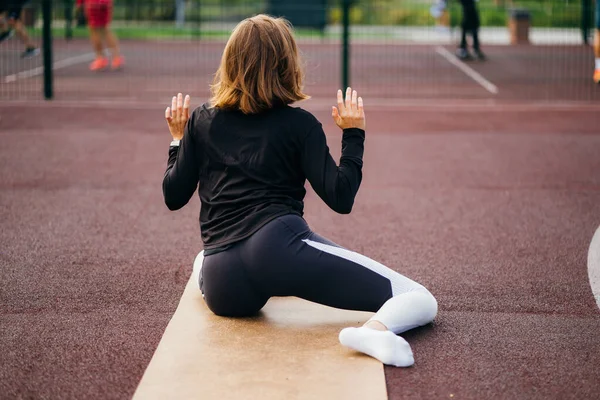 Jovem mulher em forma de sportswear trens ao ar livre no parque infantil. — Fotografia de Stock