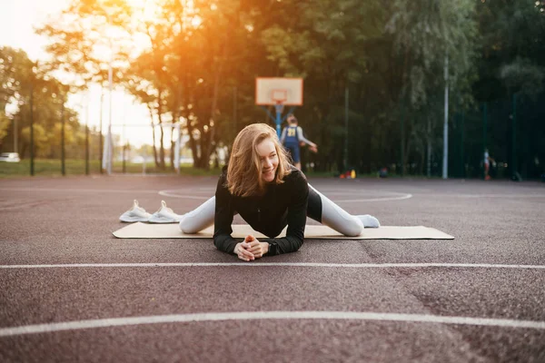 Junge, fitte Frau in Sportkleidung trainiert draußen auf dem Spielplatz. — Stockfoto