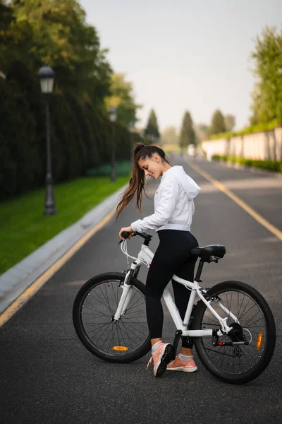 Menina bonita posando na bicicleta branca. Caminhada na natureza. — Fotografia de Stock