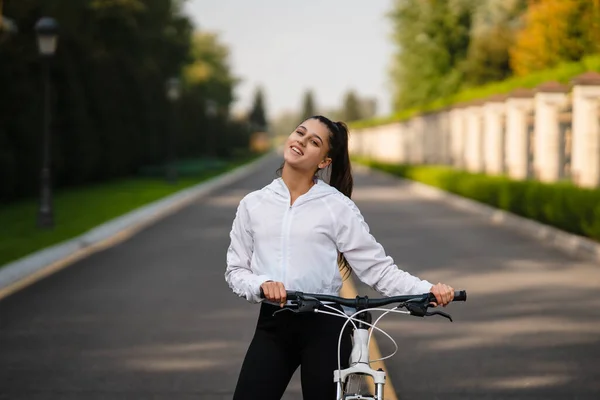 Menina bonita posando na bicicleta branca. Caminhada na natureza. — Fotografia de Stock