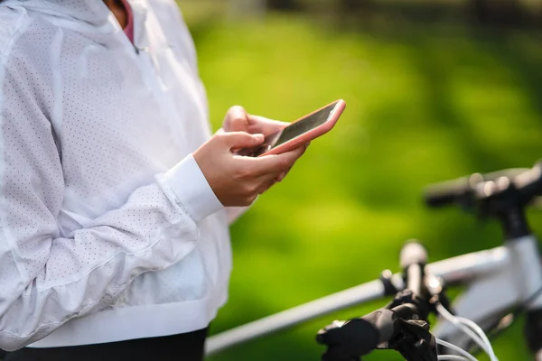 Młoda kaukaska kobieta odpoczywa w parku, używa telefonu komórkowego. — Zdjęcie stockowe