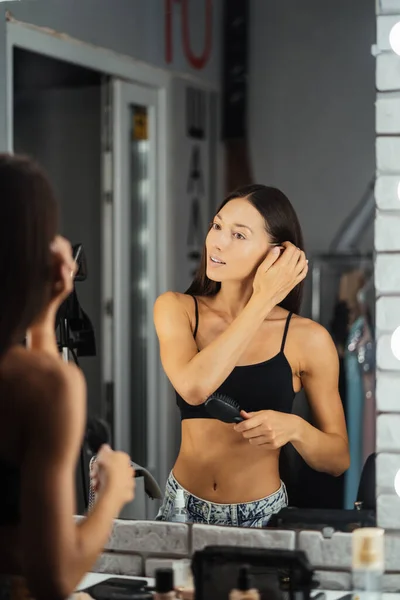 Reflejo de la joven hermosa mujer que aplica su maquillaje —  Fotos de Stock