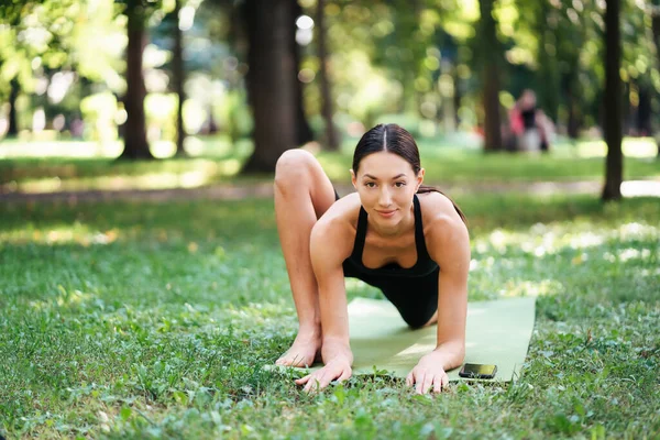 Atletik genç kadın sabahları parkta yoga yapıyor.. — Stok fotoğraf