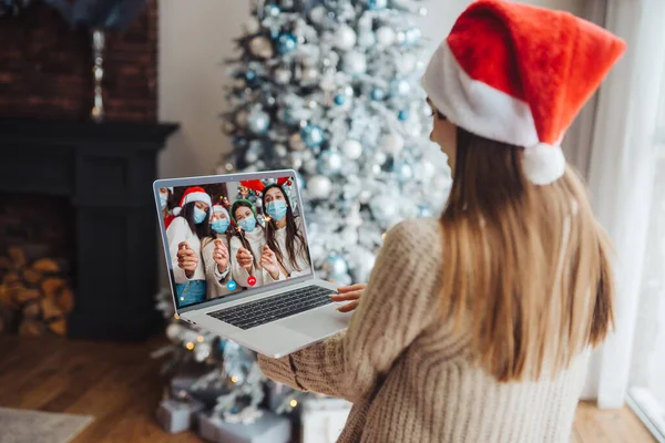 Perempuan mengenakan topi santa saat berbicara dengan teman online di laptop — Stok Foto