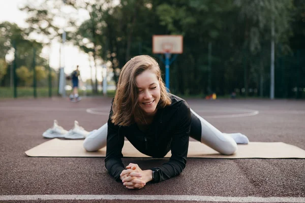 Mujer joven en forma en trenes de ropa deportiva al aire libre en el patio de recreo. — Foto de Stock