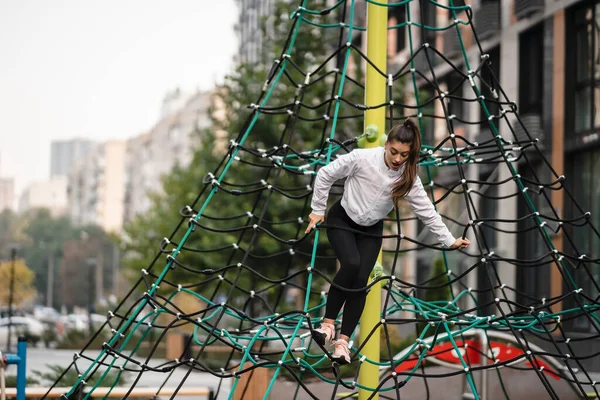 Jeune femme s'amuser sur la pyramide de corde — Photo