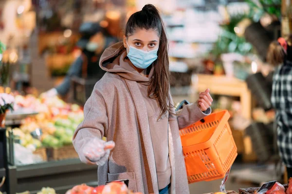 Mladá žena v ochranné masce nakupuje — Stock fotografie