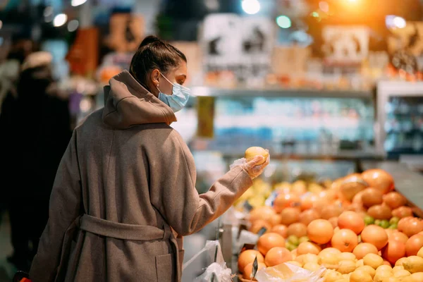 Jeune femme en masque de protection fait des achats — Photo