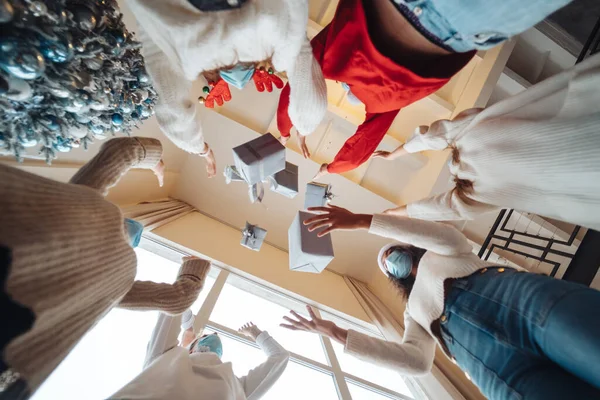 Des amis multiethniques jetant leurs cadeaux de Noël dans les airs. — Photo