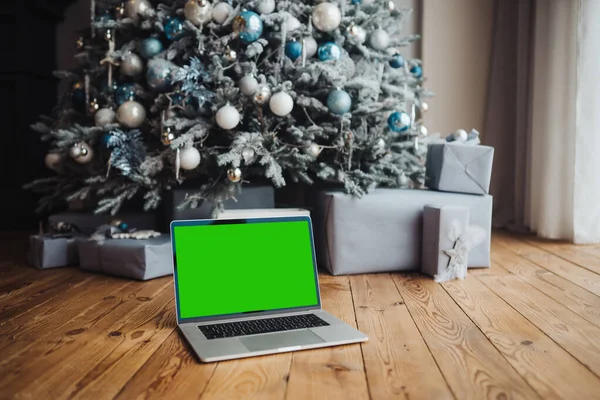 แล็ปท็อปที่มีหน้าจอสีเขียว โครเมคีใกล้กับการตกแต่งปีใหม่ ธีมคริสต์มาส . — ภาพถ่ายสต็อก