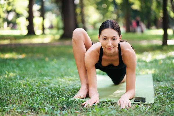 Atletik genç kadın sabahları parkta yoga yapıyor.. — Stok fotoğraf