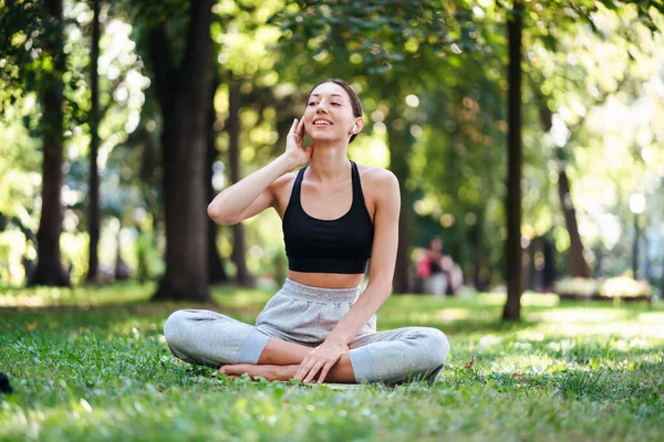 Fitness-Mädchen mit Smartphone auf Naturhintergrund. — Stockfoto