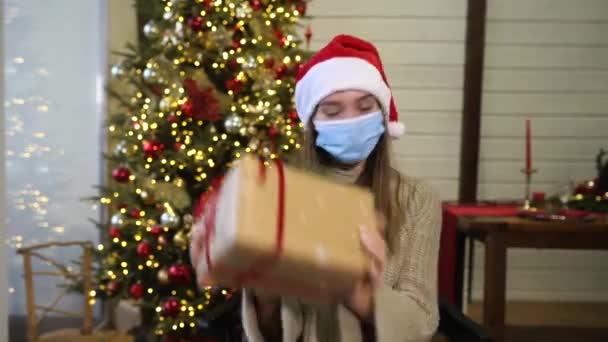 Dívka drží vánoční dárek na Silvestra.